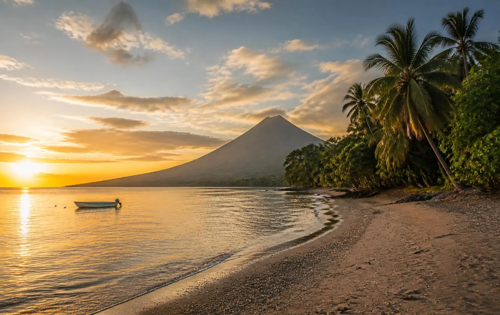 Quiet Central American coastline at sunrise with volcanic hills and low development